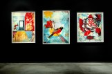 A modern art gallery with a black wall displaying three framed art prints. The left print has geometric shapes, the center a…
