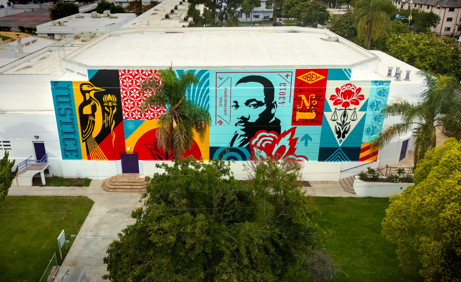 An aerial view of a vibrant mural on a building featuring a bird, Martin Luther King Jr.'s portrait, and various patterns in&hellip;